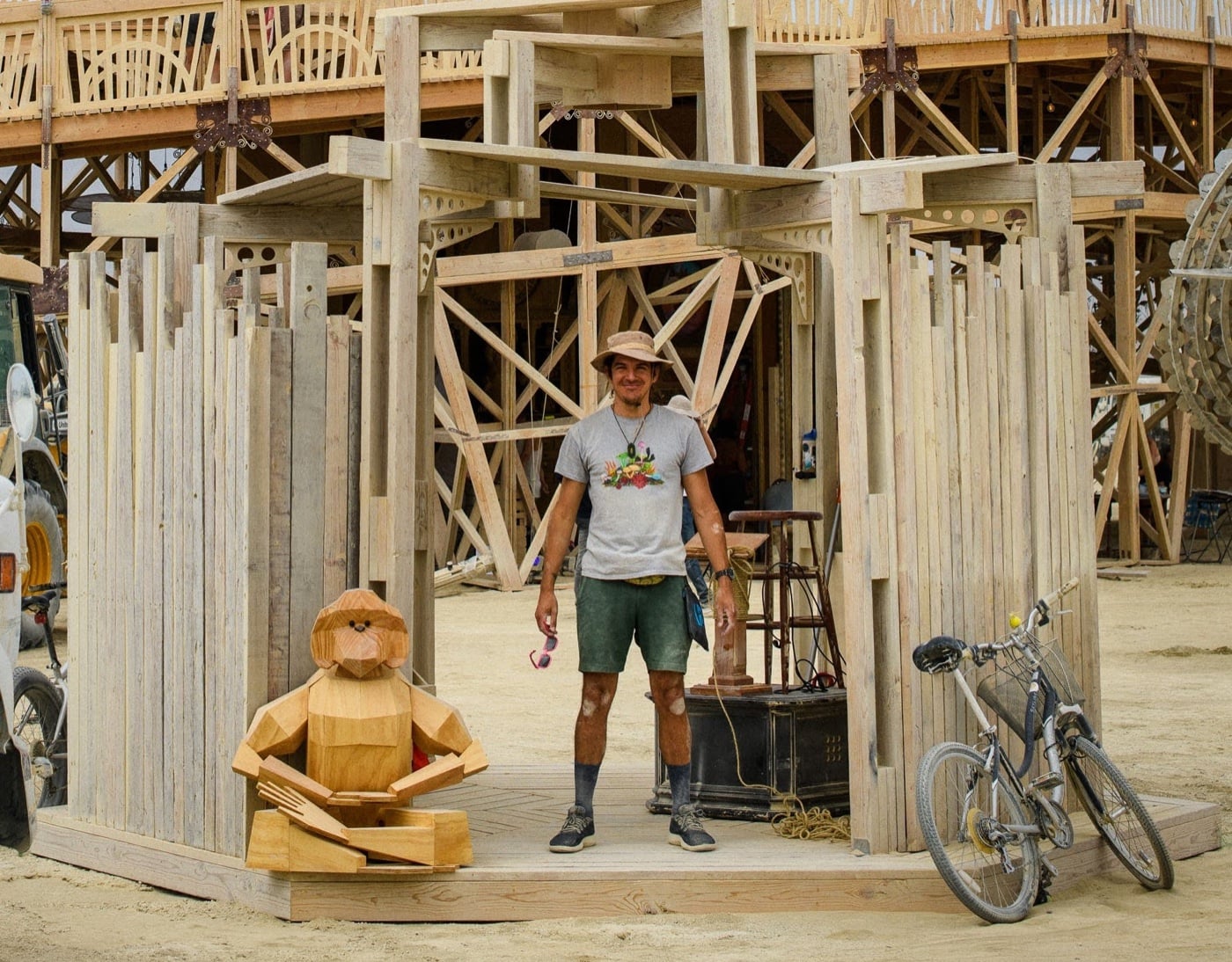 David setting up at Burning Man 2025, with a wooden sculpture of SAN.